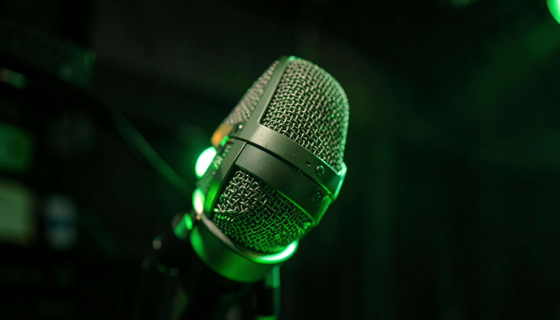 Close-up of a radio studio microphone with green accent lighting